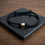 Zwarte armband met gouden kubus