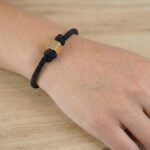 Zwarte armband met gouden kubus