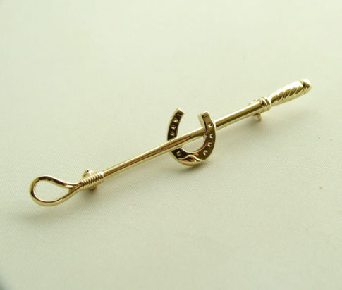 Gouden broche (zweep met hoefijzer)