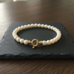 Parel armband met geel gouden slot