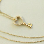 Gouden collier en zirkonia harten sleutelhanger