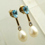Gouden oorbellen met topaas, diamant en parel