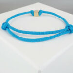 Blauwe armband met gouden kubus