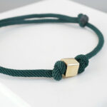 Donker groene armband met gouden kubus
