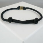 Zwarte armband met gouden kubus