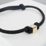 Zwarte armband met gouden kubus