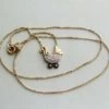 Gouden collier met kinderwagen hanger