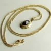 Gouden collier en hanger met granaat