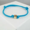 Blauwe armband met gouden kubus
