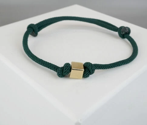Donker groene armband met gouden kubus