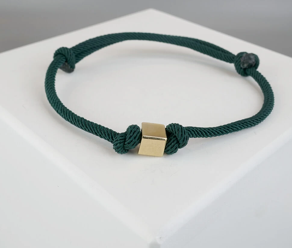 Donker groene armband met gouden kubus