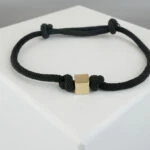Zwarte armband met gouden kubus Zwarte armband met gouden kubus