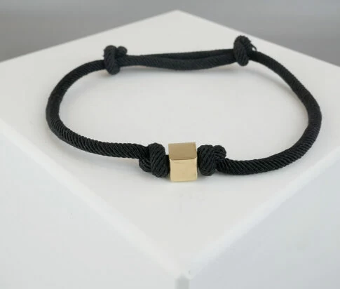 Zwarte armband met gouden kubus