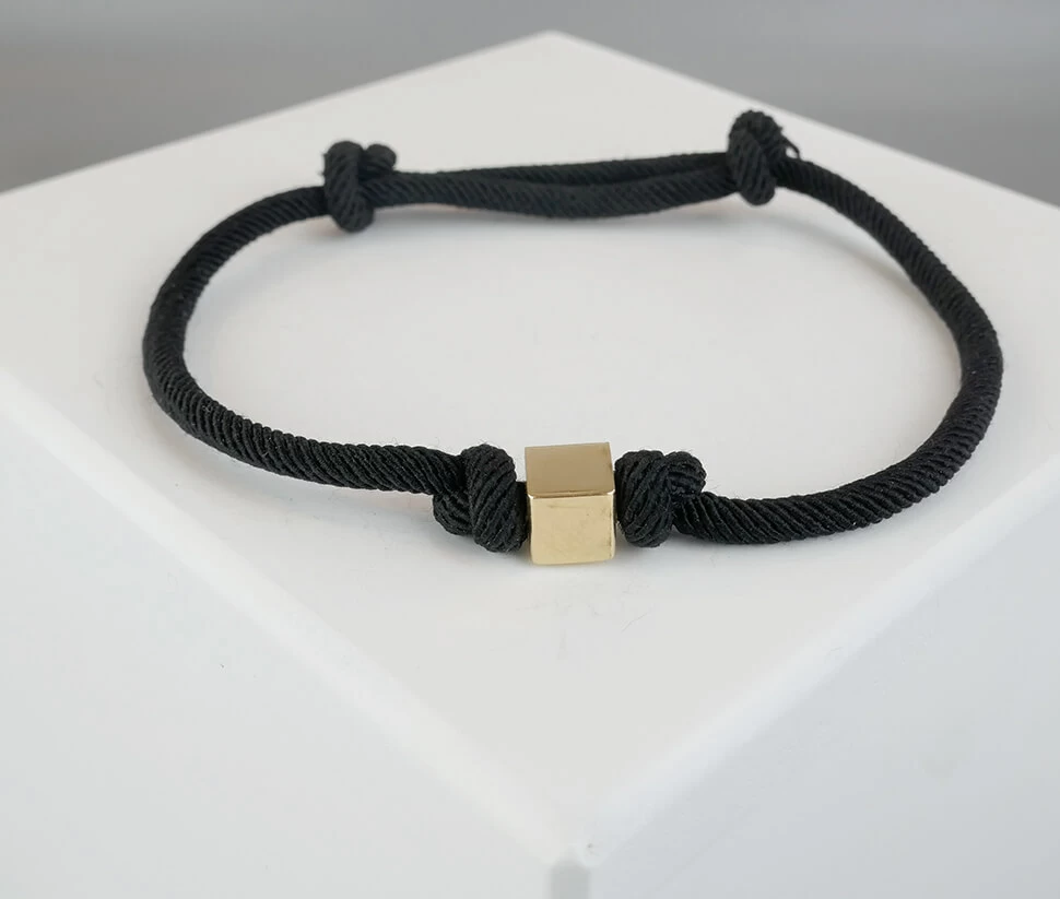 Zwarte armband met gouden kubus